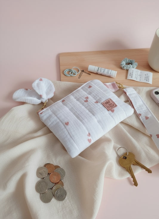 carteira pequena em musselina com corações com fita para segurar no pulso em tons rosa e branco